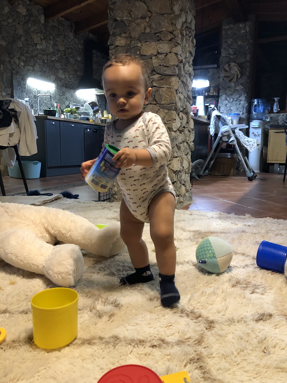 Nestaground organic wool rug in a family living room — child playing near parents, natural handmade rug at the centre of the home